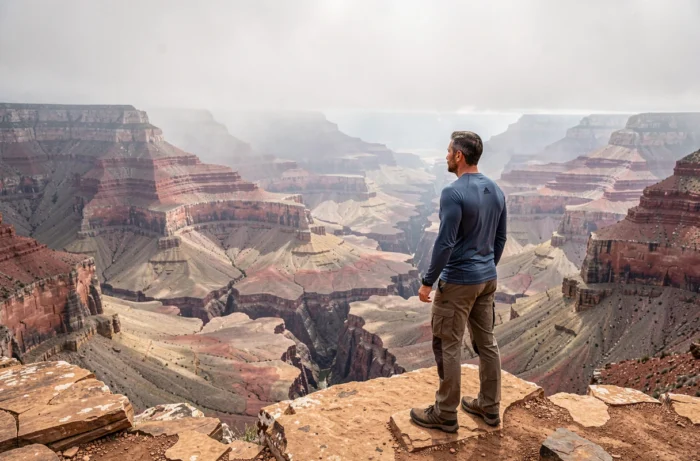 Randonneur admirant un canyon spectaculaire en Amérique du Sud lors d'une aventure autour du monde